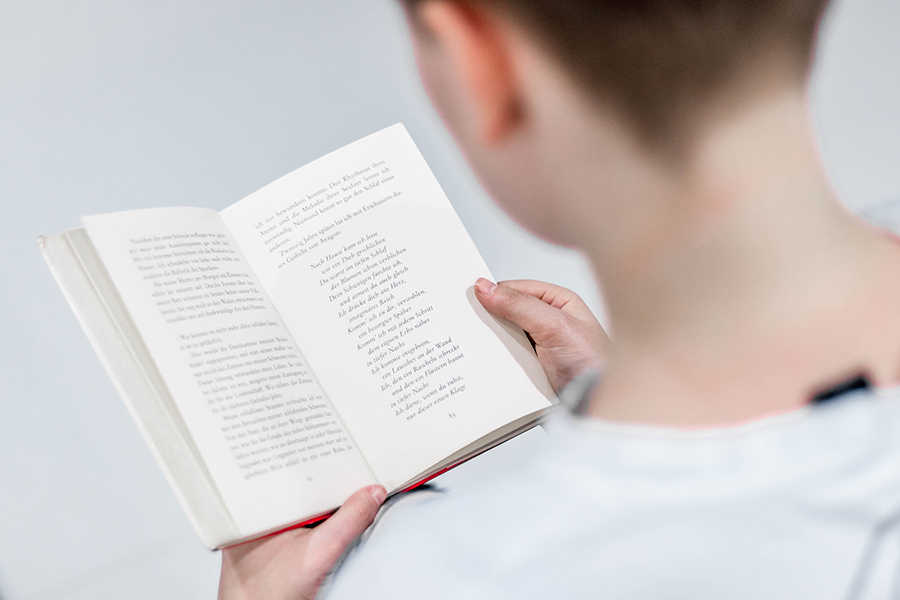 Person reading book over shoulder