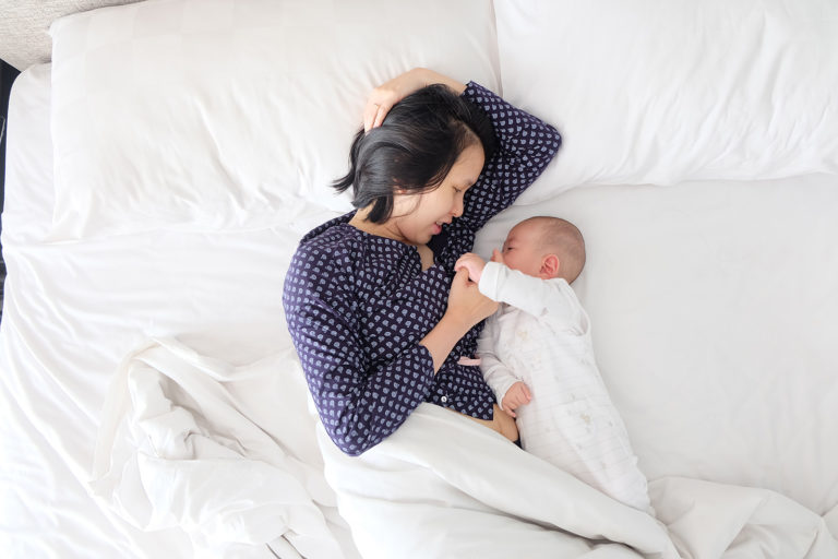 Mom and baby cuddling in bed