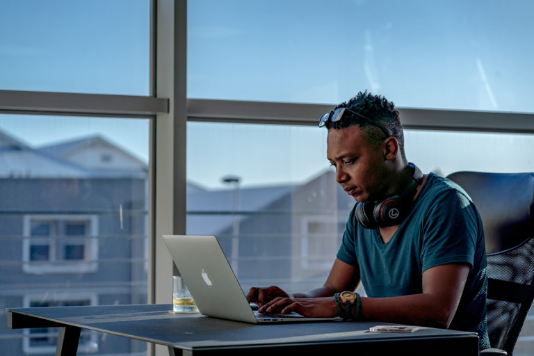 Man on laptop near a window