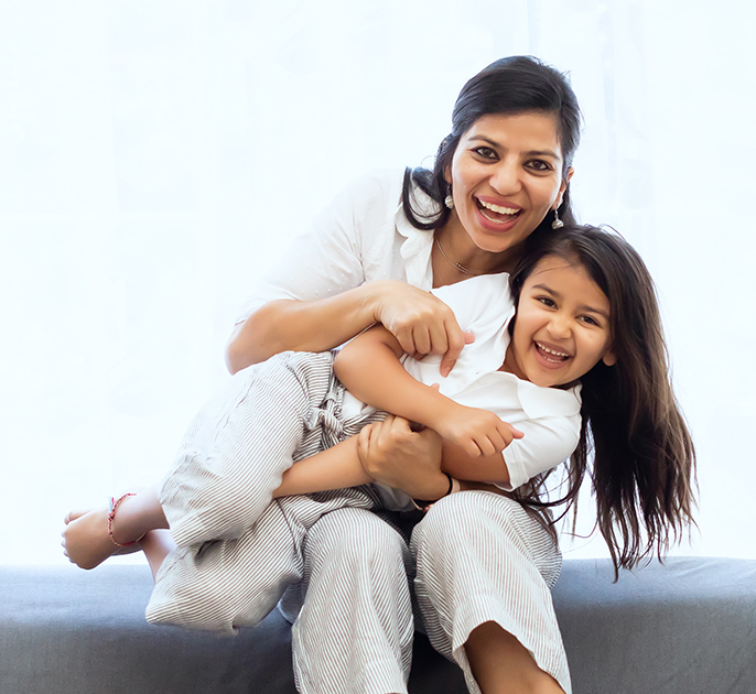 Mom and daughter embrace on a couch